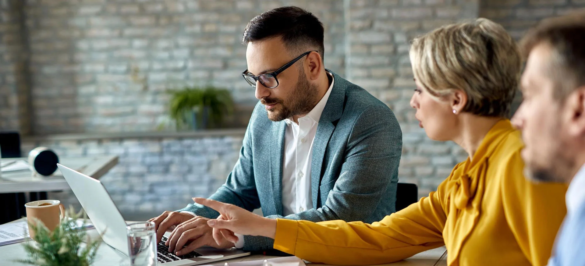 Financial advisor working on a computer while having a meeting.